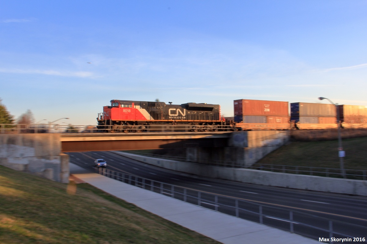 Canadian National SD70M-2 8018 brings up the rear of hotshot intermodal Q102 as they are nearing the end of their journey, passing Thornhill, Ontario as they slowly (but quickly in the photo) creep up to a slow order at CN Snider.