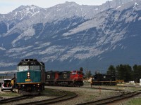 The Canadian waits for the passengers to board before departing as a CN freight ducks into the yard at Jasper.