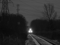 Despite the mild winter in Ontario, the beginning of spring has not been so nice. For two days in a row in Niagara, it has snowed. Behind a pair of ES44AC's, CN 330 eases towards the interlocking at Port Robinson West, and will soon be in Port Robinson Yard. A light snowfall is illuminated by 330's headlights. The two signs adjacent to the track on the left side of the photo are whistleposts from Barron and Allanburg Road. The carnage of power lines in the area are thanks to the Allanburg transformer station a short walk away, which provides a good percentage of Niagara's hydro. At one point, CN used to provide dimensional loads to the station, however the switch has long since been removed.