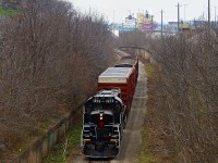 After working the Grantham Spur in St. Catharines, TR 1859 heads back towards Welland with four boxcars, including one hi-cube. From recent observations, it appears this is typically a Monday and Friday run. 1859 is without a doubt the cleanest unit Trillium has, and it appears the crews may take pride in cleaning it, something unheard of on class 1 railroads. The conductor clearly has some knowledge of railroad photography, as he very nicely dimmed the lights for me, and proudly waved. In the distance, two ships make their way through Locks 4-6 on the Welland Canal, while another descends Lock 7 just to the right of the photo.
<br><br>
Back when this was CN's mainline to and from Buffalo, it was double track. That changed around the 1970s, and only westbounds took this route downhill due to the ridiculously steep grade, as well as the odd local like 549. Bridge 10 was dismantled in 1997, effectively splitting the Thorold Sub in half and pushing all trains onto the Stamford Sub. Today it is the Thorold Spur as used by Trillium. Arnold Mooney's shot from just months prior to Bridge 10's dismantling shows some of the few changes that have occurred. 
<br><br>
http://www.railpictures.ca/?attachment_id=7959
<br><br>
As always, significant tree growth as occurred. And anything longer than a stubby local just doesn't happen anymore, besides when CP goes on strike. Emergency detours on CN do warrant a possibility, but taking the Hamilton Sub the entire way would offer much less hassle and would be safer. For now, enjoy Trillium!