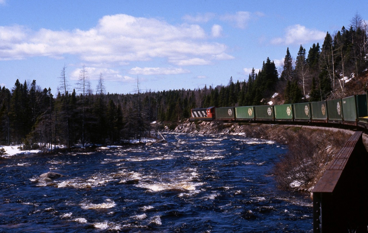 DOWNGRADE AT KITTY'S BROOK - As photographed from the vestibule of Coach 757, Terra Transport Mixed Extra 935 West with single unit NF210 935 has just crossed the first of two bridges over that brook overflowing with spring run-off on April 20, 1987. This view gives some perspective of the grades encountered on the former Newfoundland Railway during the photographer's first of five runs on the Bishops Falls to Corner Brook mixed service. By now the railway was pretty much fully containerized but living on borrowed time.