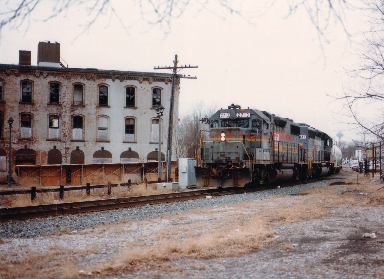 For those who are old enough, and lived in the Falls; this photo should bring back a lot of memories. CSX is heading stateside, barely out of sight of the bridge in this photo, with a couple of worn units, 2713 in Seaboard Coast Line paint, and the following 8182, in a later Seaboard scheme, But the focus of the photo is on the old King Edward Hotel, the notorious 'King Eddy', one of those infamous landmark old boozers of the past. One can see it is already in the process of demolition when this picture was taken, and now, just like the track thru town, is just a memory.