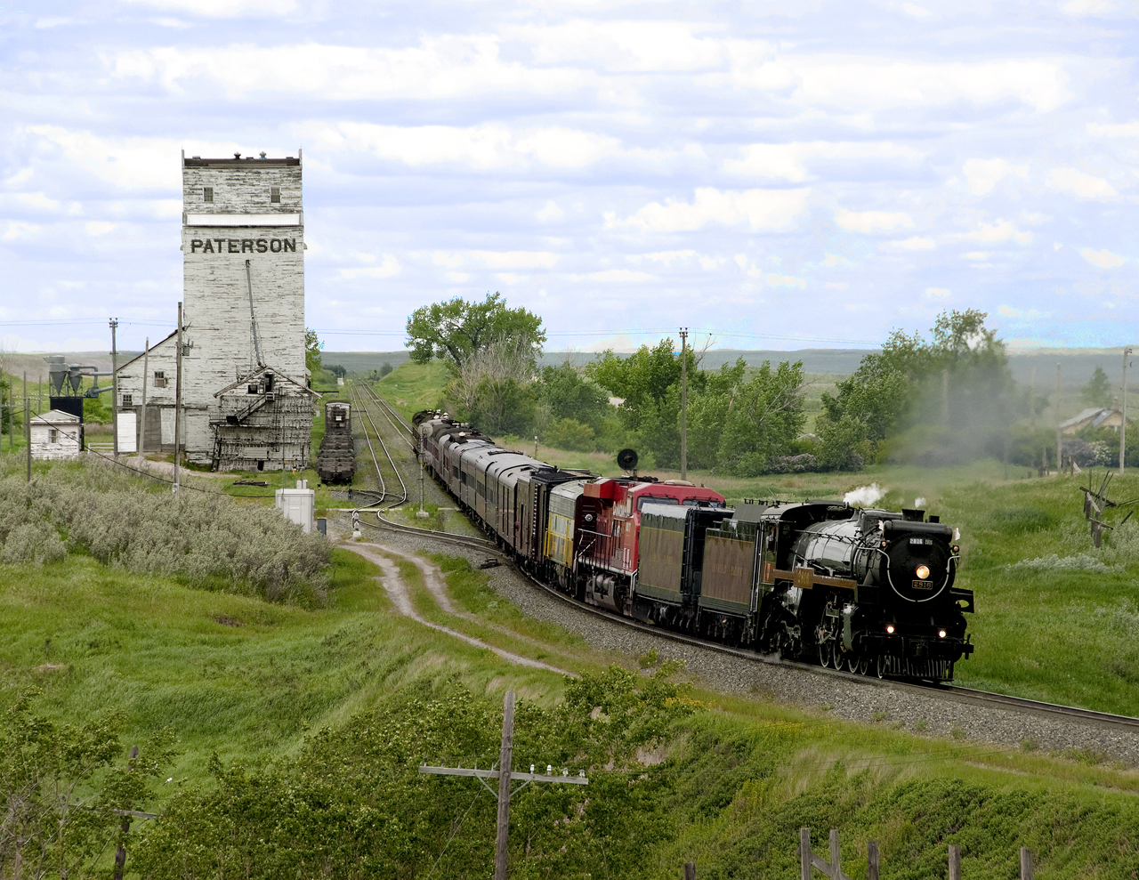 An eastbound executive special bound for Regina for a meeting with Premier Wall to dedicate start of a new intermodal terminal passes a wooden grain elevator west of Moose Jaw