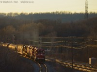 <b>Part deux of the pusher series:  Ontario's newest pusher territory continues: </b> At last light,  three gp38-2's in notch 8 fill the air with the sounds and smells of diesel engines doing what they do best - shoving an ethanol train up the Waterdown hill. When this <a href=http://www.railpictures.ca/?attachment_id=15354 target=_blank> started in 2014 (click for photo)</a> the operation seemed clumsy as some crew needed familiarization with the procedures (while others did not). These days the crews have it down to a science and they are efficient and swift with the adding of, and application of pushers in this relatively new pusher district. Nice show boys, keep up the fine work!<br><br>This spring, CP is using pushers about once to twice a day, while CN about once or twice a week. Considering both CN and CP regularly use pushers at this very location, Hamilton West is definitely the place to be, as it was 50 years ago in the days of steam (Anyone have vintage pusher shots from here? Please share! cheers!) 