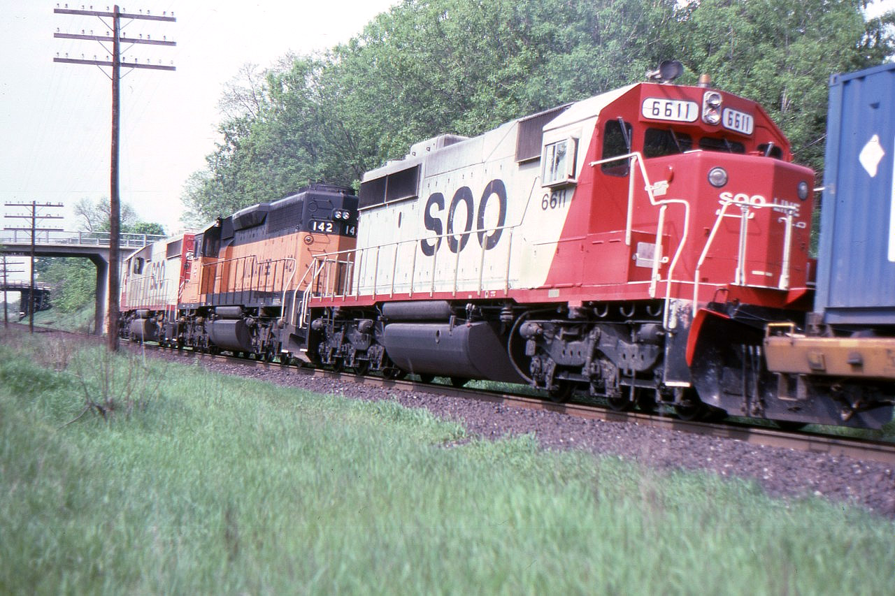 A few months before this photo was taken, SOO Line took over much of the eastern part of the bankrupt Milwaukee Road. A number of locomotives were included in the deal and here we see MILW SD-40-2 142 still in full Milwaukee paint between SOO 6615 and 6611. The train is westbound approaching the Elgin Street bridge at mile 164 Belleville Sub.