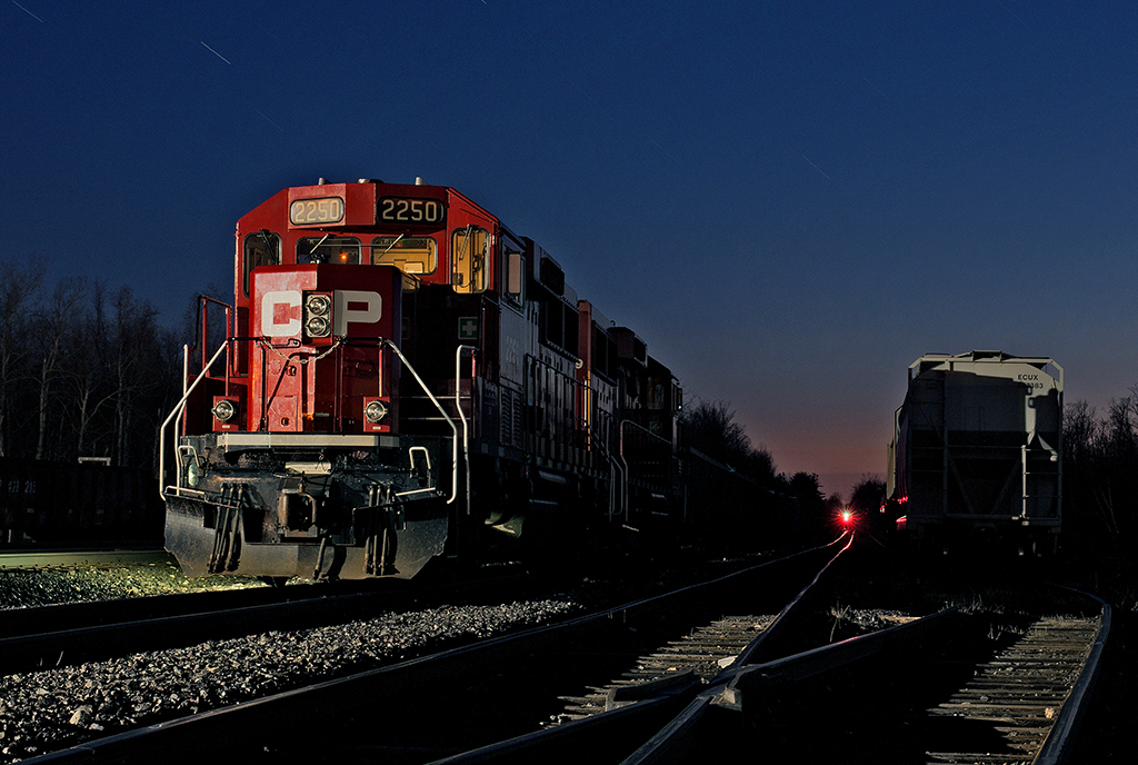 Idling ECO's  A beautiful spring day comes to a close, but it's another day on the railroad, a clear signal in the far background adorns the westward signal at Guelph Jct. for a westbound freight that's climbing the hill. The gentle sound of two 8 cylinder turbocharged 710G3's from this pair of GP20C-ECO's idle away in mainline one track with a tie train from London.