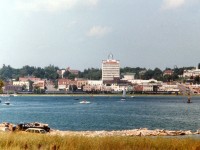 As seen across Kempenfeldt Bay, an arm of Lake Simcoe, the VIA Canadian #9 heads northward past downtown Barrie. Power is VIA 6516, 6621 and 6618. The train has just left the station stop at Allandale, and for photography, everywhere is into the morning sun save for this location, as far as I knew. Times have changed. The track has been replaced with a bicycle/hiking trail, after the train service was discontinued in 1997 and the rails lifted. About center in this image stood the early Barrie station, it was unfortunately demolished back in 1962.