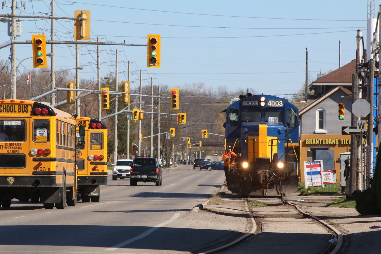 Conductor John Sharpe is keeping an eye for pedestrians and motorists alike that are not aware they are sharing the road with a larger force. This is the once a week SOR train 598 that serves the only remaining customer on the old Burgord spur. The one time Southern Pacific GP9 has one car in tow and will lift four more before returning to the CN yard in town.