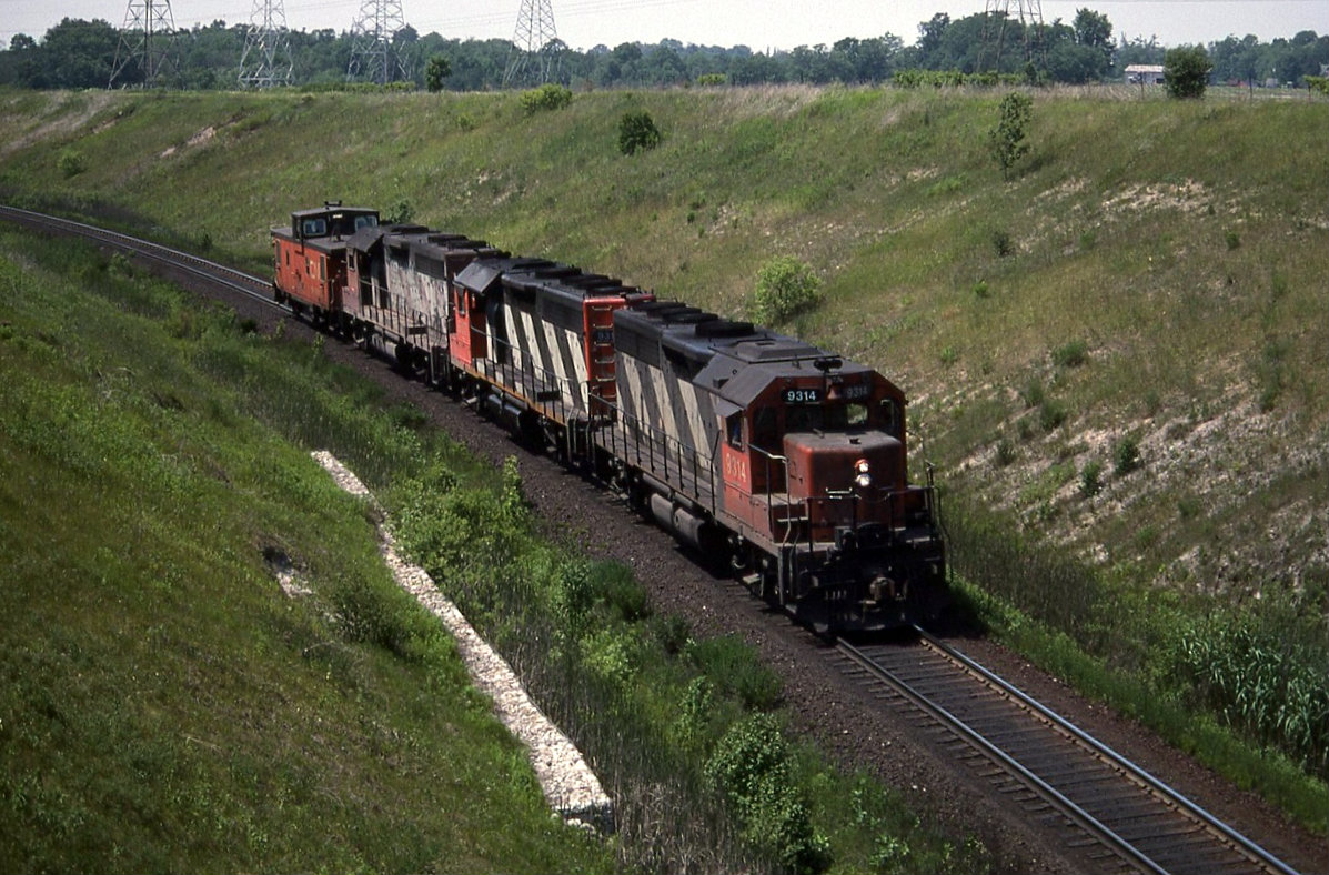 Running light CN 413 east  with three standard cab GP40,s rounds the curve at the top end of Barr on its way to Oshawa to lift its west bound train.