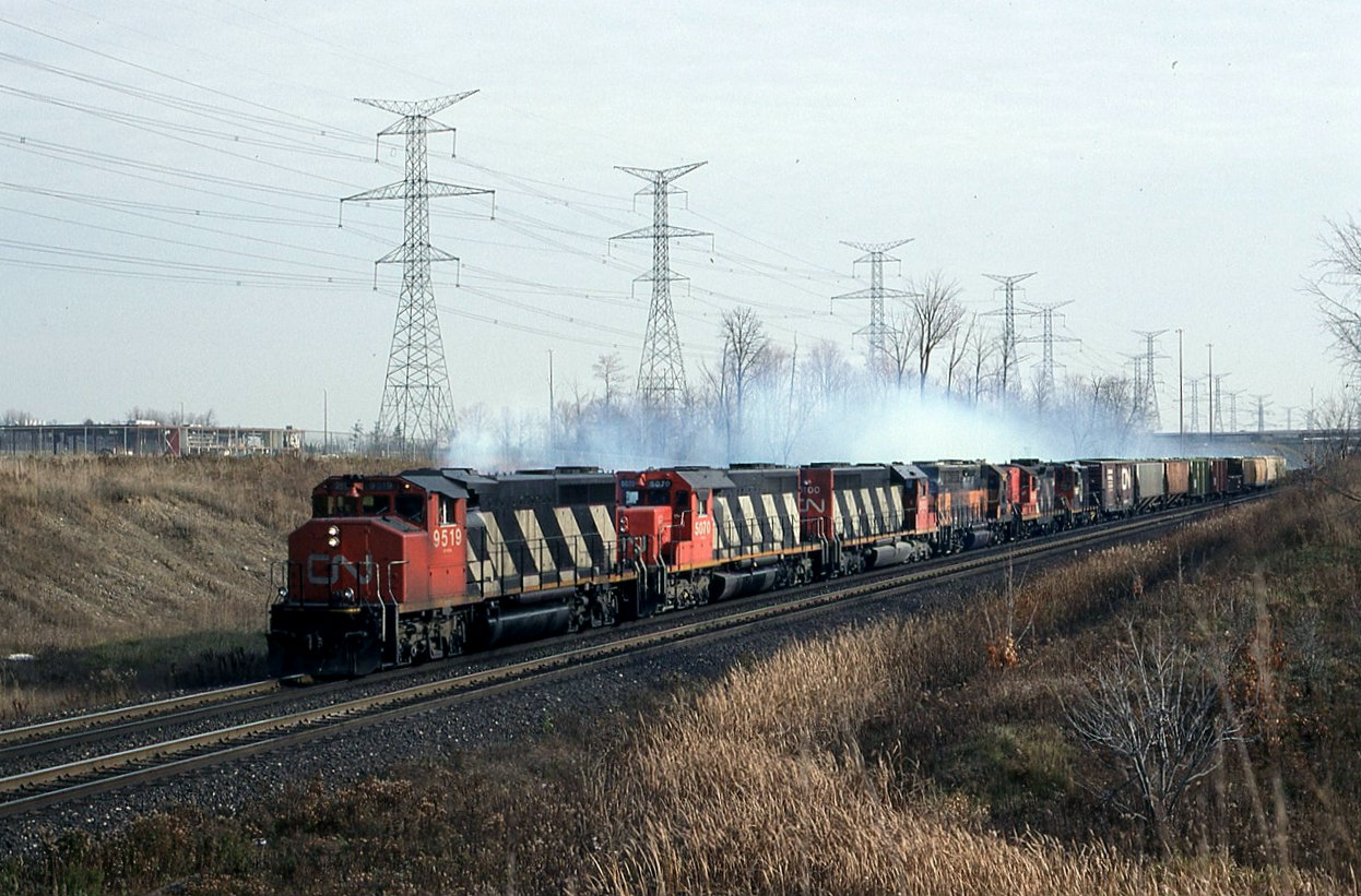 Help with location please, info lost. CN 381 with 9519 5070 5100 an unidentified MILW unit CN GP9 and a Sweep accelerate west bound some place in  Toronto.