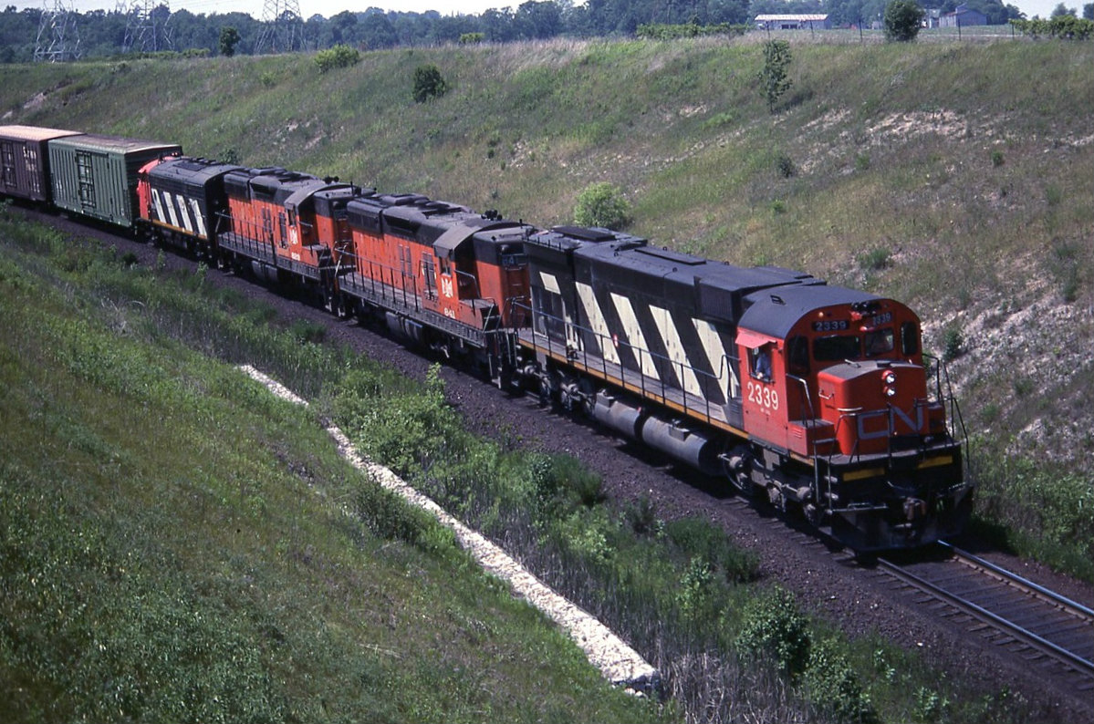 CN M636 2339 with B&LE SD9,s 841 & 823 along with an unidentified CN F unit round the curve east bound at Plug hat road toward the top end of Barr on the York sub. Both of the B&LE units where scrapped in 2000.