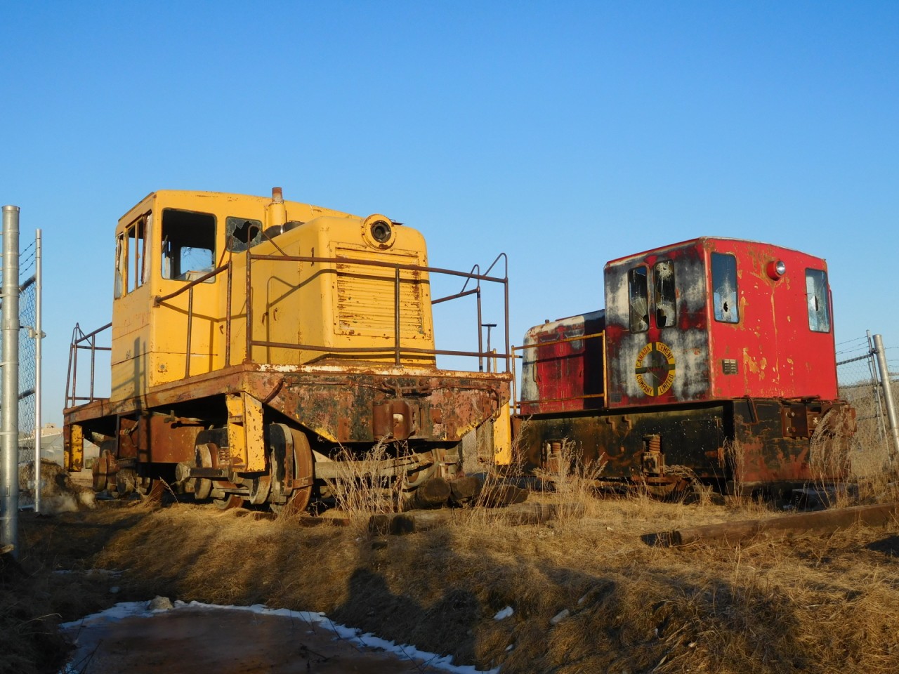 A pair of very old GE's continue to rust away in the Fort Garry Industrial in Winnipeg. The yellow unit (Canada Cement 641) is a GE 50-ton built in May 1947, the red unit (Canada Cement #?) is a GE 15-ton built in April 1955. These units will never run again, unless they get extensive repairs. They are quite clearly in very bad shape, with the windows being smashed, paint fading, and metal rusting. Very sad seeing them like this