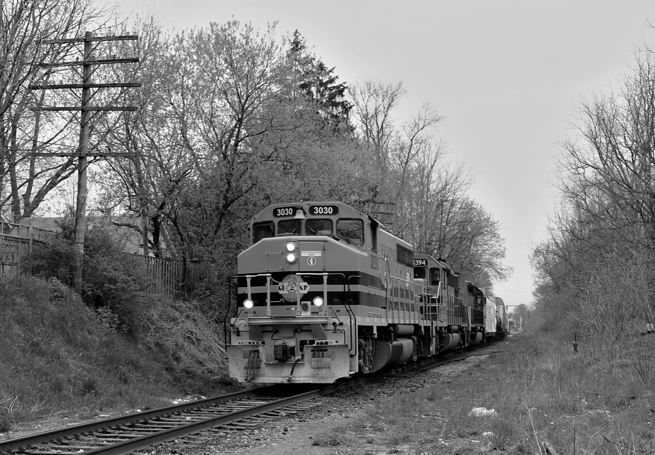 GEXR 431 heads west approaching the visibility-restricted crossing of Edinburgh Road at mile 49.54 with a classic Canadian wide cab on the point.  The 100 axle train was to drop most of it's tonnage at Kitchener, where GEXR 518 was working the yard.  At right, there are 2 switch stands, only one is visible, left from the south main track, which was removed in 2013.