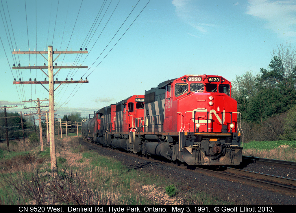 CN 9520 leads a westbound through the curve and is about to pass under the wooden bridge of Denfield Road in Hyde Park, Ontario back on May 3, 1991.