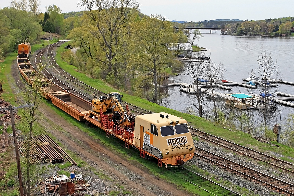 This Herzog tie train graced Huntsville Yard with its ugliness over the Victoria Day long weekend. The previous week a load of ties heading north in rickety old gondolas caught fire south of Gravenhurst and was suspected of igniting a half-dozen brush fires between there and around Mile 145 of the Newmarket Sub before smoke was noticed and the offending car cut out of the train and attended to by firefighters. The well-type cars used on this train appear to be a bit more fireproof. As a footnote, James Hoffman informs me that this contraption has an EMD 645 prime mover and a Leslie horn, so it sounds a lot better than it looks!