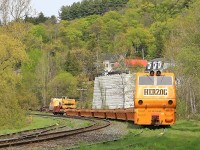 This Herzog tie train graced Huntsville Yard with its ugliness over the Victoria Day long weekend. The previous week a load of ties heading north in rickety old gondolas caught fire south of Gravenhurst and was suspected of igniting a half-dozen brush fires between there and around Mile 145 of the Newmarket Sub before smoke was noticed and the offending car cut out of the train and attended to by firefighters. The well-type cars used on this train appear to be a bit more fireproof. As a footnote, James Hoffman informs me that this contraption has an EMD 645 prime mover and a Leslie horn, so it sounds a lot better than it looks!
