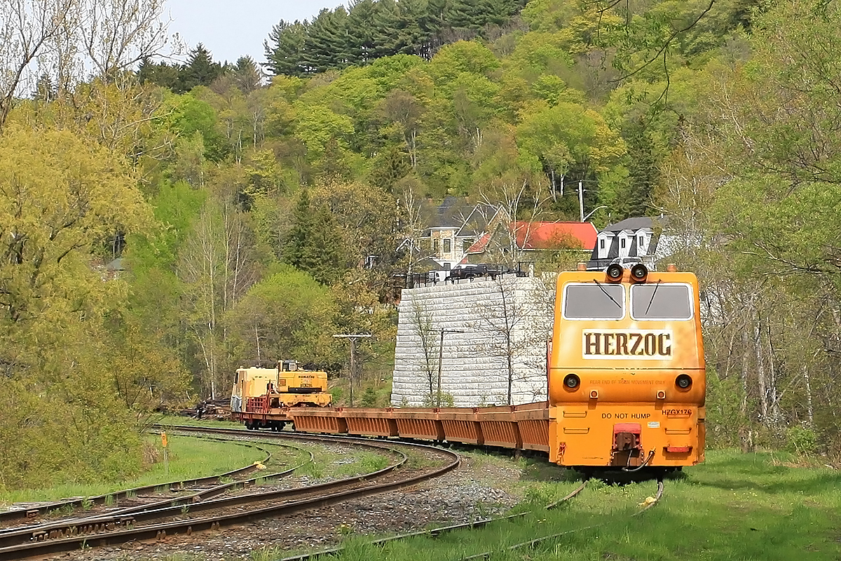 This Herzog tie train graced Huntsville Yard with its ugliness over the Victoria Day long weekend. The previous week a load of ties heading north in rickety old gondolas caught fire south of Gravenhurst and was suspected of igniting a half-dozen brush fires between there and around Mile 145 of the Newmarket Sub before smoke was noticed and the offending car cut out of the train and attended to by firefighters. The well-type cars used on this train appear to be a bit more fireproof. As a footnote, James Hoffman informs me that this contraption has an EMD 645 prime mover and a Leslie horn, so it sounds a lot better than it looks!
