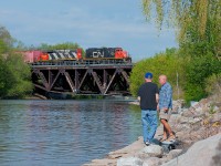 Two local fisherman go on about their morning as CN 556 trundles east with cars for Distribution, Metro and Lantic Sugar.  