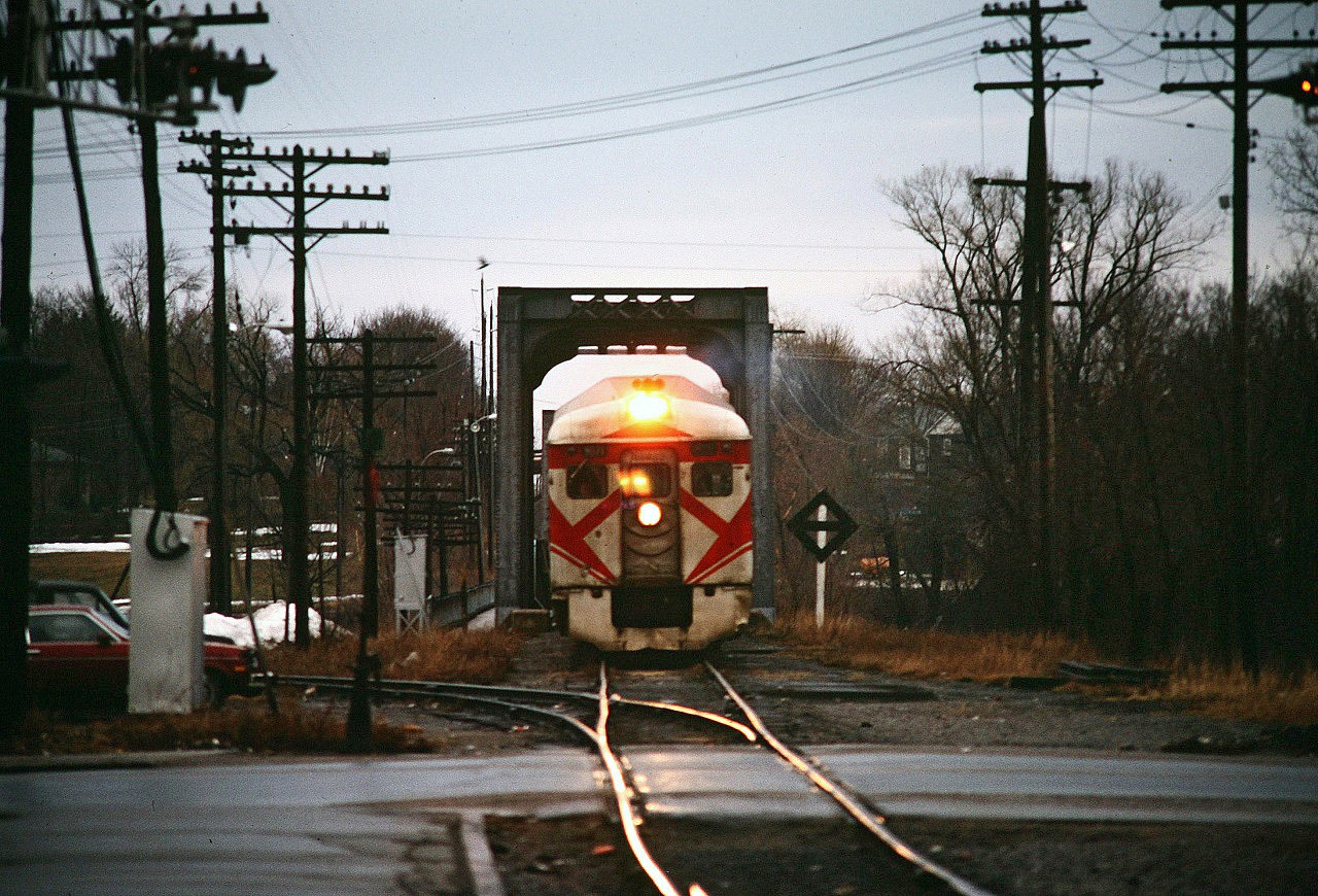 How it all began. This photo of the Sunday evening Havelock to Toronto Dayliner taken by brother best exemplifies my introduction to railroading. I was born and raised in Peterborough. Our family would use the Saturday train for trips to Toronto. The train would seem to take forever to arrive due to the city's 10 mile per hour speed limit. No horn blowing either. All you could do was wait and watch the Mars light flash as it slowly made its way to the station. I have lots of good memories of these trips, seeing the countryside, passing through Agincourt yard, crossing the Leaside bridge, the then filthy Don River, Don Yard and into Union Station. I vividly remember one trip back from Toronto during a blizzard, probably in 70 or 71. Drifts had blown across the line, and in the open stretches the engineer accelerated as much as possible before hitting the drift. Once we hit the drift, you could feel and hear the car pushing through the drift. The speed would drop and drop until finally we would break through. Then we would accelerate as quickly as possible before the next drift. When we arrived in Peterborough the crew were looking under the first car. The drifts had dislodged a 5 foot square pan on the underbody which was now only secured by a 4 inch wide strip of aluminum and dragging on top of the rails which could have caused us to derail. The crew tried going back and forth a few times to dislodge it to no avail. In the mid 70s we started driving to Pickering and taking the GO train in to Toronto. I didn't ride again until 1981 when I went to college in Scarborough, and used it for a few trips home until the train was cut by VIA.