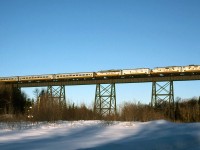 The northbound Snow train crosses Bellevue trestle early on the morning of January 14, 1998. 1751, 1753, 1761 and 1768 head for Agawa Canyon with 18 cars. The 1761 had just been released for service a week prior after receiving some work and new paint and it glows in the low winter sun.