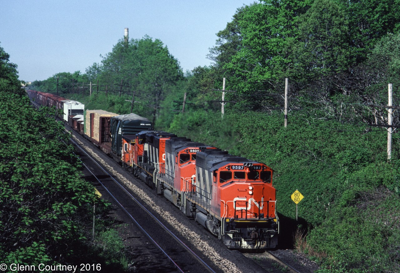 The almost standard CN freight in southern Ontario 30 years ago - a trio of GP40-2Ws. This trio is westbound on the Oakville Sub approaching Bayview. Note the wrecked BC Rail boxcar riding the flat car, obviously a candidate for scrapping.