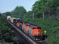 The almost standard CN freight in southern Ontario 30 years ago - a trio of GP40-2Ws. This trio is westbound on the Oakville Sub approaching Bayview. Note the wrecked BC Rail boxcar riding the flat car, obviously a candidate for scrapping. 