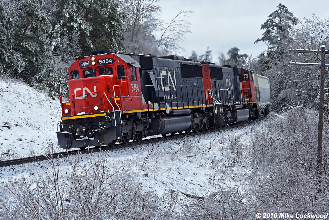 A late winter ice storm has allowed one last chance to shoot in a winter wonderland before spring weather arrives, and with slim pickings over the winter of 2015/2016 for snow in my locale, this was most appreciated. Also appreciated was the chance to shoot a 412 with CN 5454 and 5777 as power. And I have it on good word that the hogger on this train was thrilled to have the SD60 leading, appreciating the smooth and reliable power those used motors provide. Everybody wins, lol. 1314hrs.