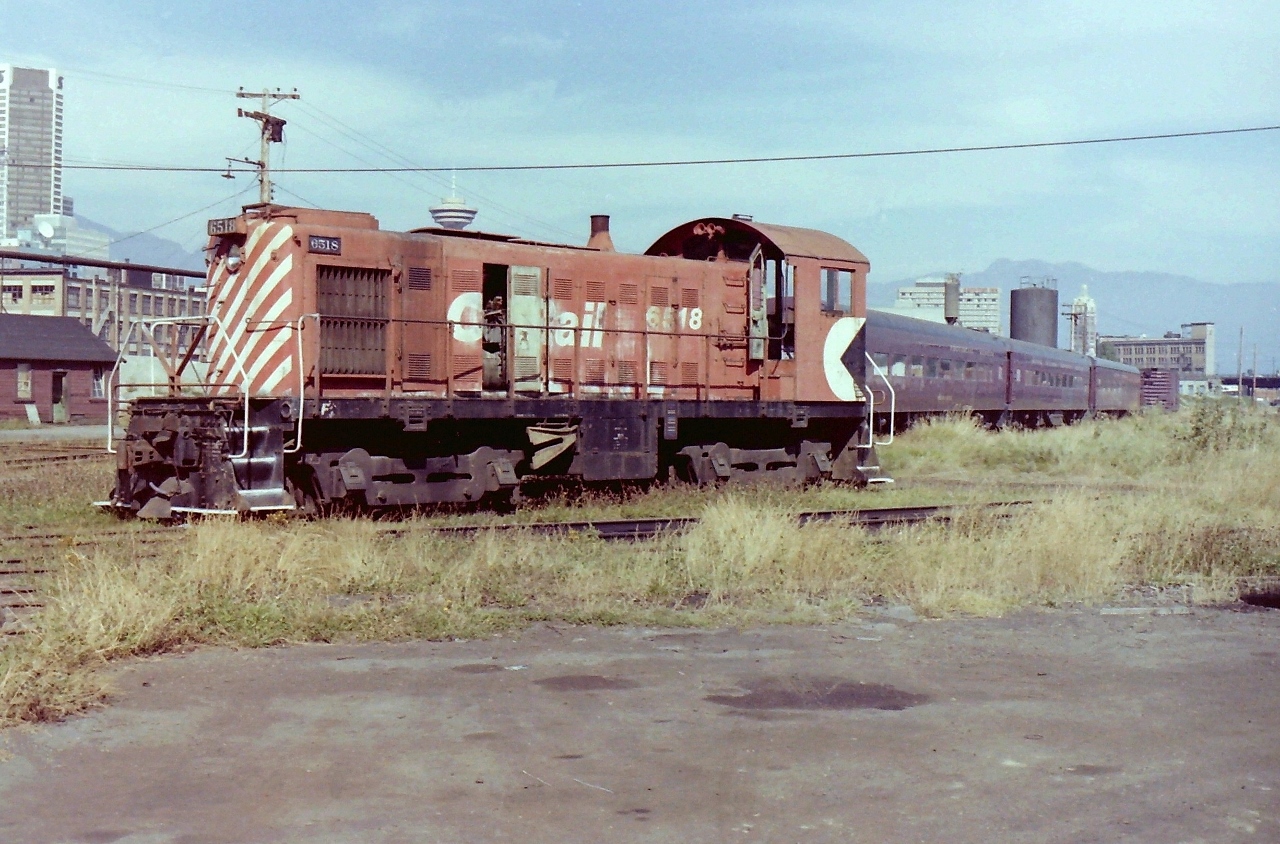 In this photograph, CP 6518 is sitting quietly near the steam era oil house @ CP Drake Street Yards. I stood back a distance from CP 6518 when I took its picture. I'm sure the idea at the time was to get a bit of the background items in as well. I guess this is what you do when you know you are running out of film. On the left side of the locomotive you can see the door leading into the old locomotive foreman's office. On the right side of the locomotive you can see 3 passenger cars, & one box car from the "BC Provincial Museum" train. The passenger cars are the "Skeena River", the "Kootenay River", the "Adventure", & the box car is the "Nanaimo River".
