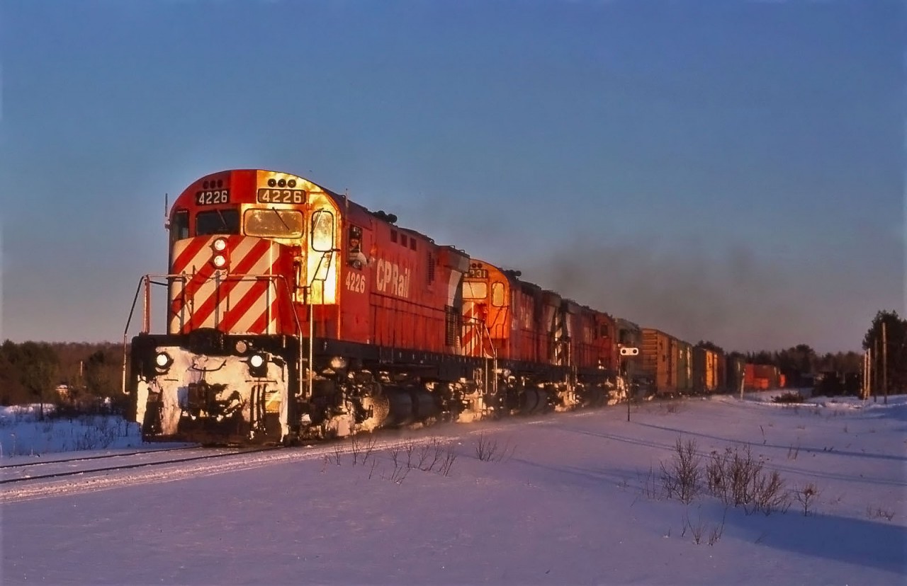 Late evening on Feb 27, 1988 and CPR train 911 is nearing Sault Ste. Marie in the last light of day with C424's 4226, 4231, 4247 and AC 183 leading 34 cars.