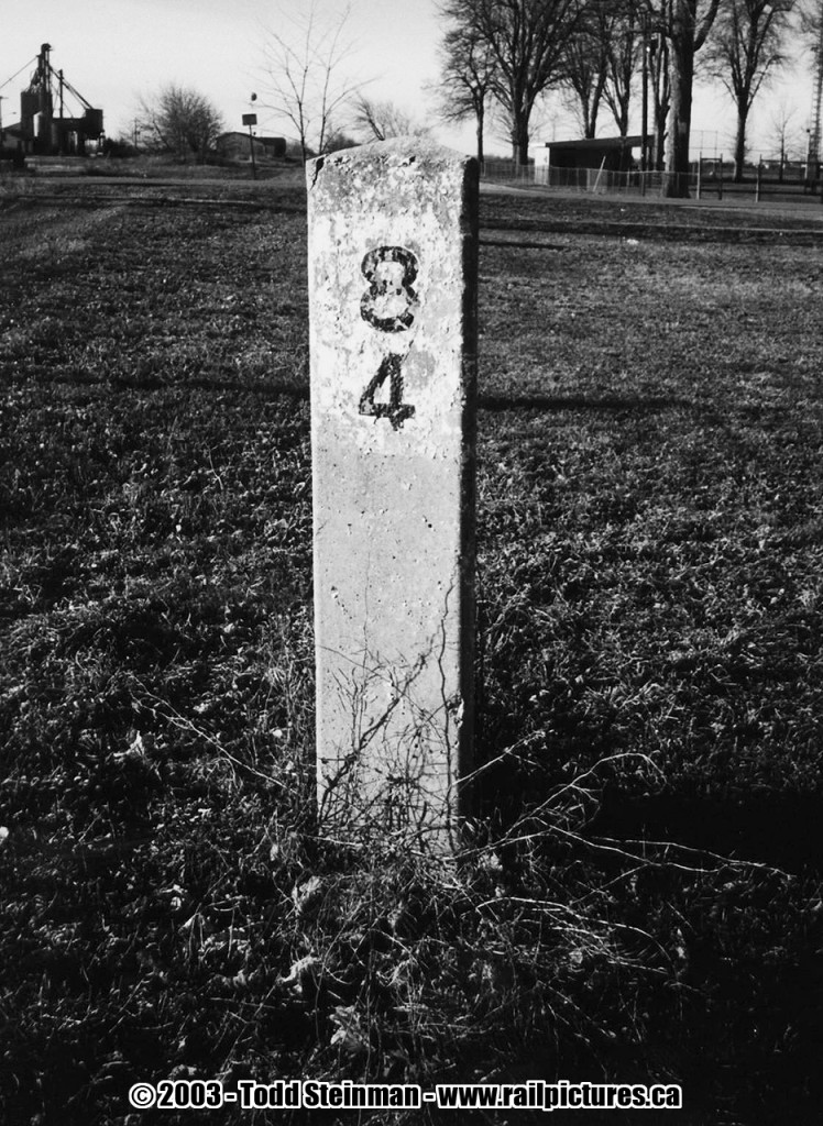 Ridgetown is one of the few towns left in Ontario that still has some existing relics from the days of rail. Not only is the CSX station still standing, but as you will see from this photo the old mile marker made from concrete. Here at Mile 84, of the CSX Blenheim Subdivision, the old roadbed is clearly visible as well as the spur that ran to the mill.
