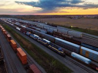 During my trip to Toronto and Whitby, I anticipated a CP 242 to pass through with a CEFX AC4400CW leading with three DME SD40-2's close behind. Didn't happen... Knowing CP's unpredictability, that shouldn't be a surprise. They ended up being dumped in Windsor to be put on CP 254. Well by the time I found out late that evening I was sure 254 was in the states, however, this train has been known to die in Welland and scramble its entire train. Sure enough, it did, and 254's online units took off and opened the spotlight for these lovely units. While CP 6242 and CEFX 1031 left afterwards, the DME units remain for now, which consist of 6366, 6363 and 6360.
<br><br>
Looking for the DME units upon arrival was a daunting task, and it took me several minutes to catch a glimpse of 6360 between the array of stored cars a containers from CP 142. Situations like this is exactly why I decided to get a drone, and it paid off. Remaining low-key with a device that has been known to send people into panic was important, and the relatively long-range of the drone allowed for it. Just under a kilometer away near a stack of railroad ties next to the northwest corner of the yard (barely visible in the left background) I stand while CP 142 works the yard next to this DME lashup.
<br><br>
For these DME units, the sunset marks likely marks their coming to an end. These units are supposedly headed to Buffalo for scrap. With the many CEFX AC4400CW's and FPON units floating around on CP, Mr. Harrison appears to be finding more cost savings in leasing and temporarily borrowing power than fixing old assets. As of now, most SD40-2 power under CP ownership that still exist are either dead in transit or stored. These ex Milwaukee Road and SOO units sure had a good run, each with 42 years under their belt.