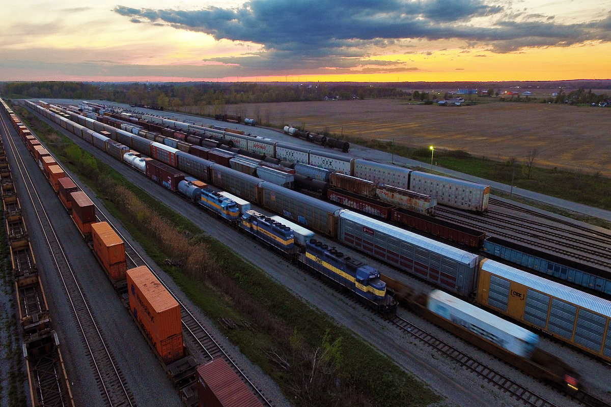 During my trip to Toronto and Whitby, I anticipated a CP 242 to pass through with a CEFX AC4400CW leading with three DME SD40-2's close behind. Didn't happen... Knowing CP's unpredictability, that shouldn't be a surprise. They ended up being dumped in Windsor to be put on CP 254. Well by the time I found out late that evening I was sure 254 was in the states, however, this train has been known to die in Welland and scramble its entire train. Sure enough, it did, and 254's online units took off and opened the spotlight for these lovely units. While CP 6242 and CEFX 1031 left afterwards, the DME units remain for now, which consist of 6366, 6363 and 6360.

Looking for the DME units upon arrival was a daunting task, and it took me several minutes to catch a glimpse of 6360 between the array of stored cars a containers from CP 142. Situations like this is exactly why I decided to get a drone, and it paid off. Remaining low-key with a device that has been known to send people into panic was important, and the relatively long-range of the drone allowed for it. Just under a kilometer away near a stack of railroad ties next to the northwest corner of the yard (barely visible in the left background) I stand while CP 142 works the yard next to this DME lashup.

For these DME units, the sunset marks likely marks their coming to an end. These units are supposedly headed to Buffalo for scrap. With the many CEFX AC4400CW's and FPON units floating around on CP, Mr. Harrison appears to be finding more cost savings in leasing and temporarily borrowing power than fixing old assets. As of now, most SD40-2 power under CP ownership that still exist are either dead in transit or stored. These ex Milwaukee Road and SOO units sure had a good run, each with 42 years under their belt.