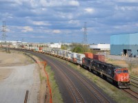 <b>A trio of EMD's.</b> CN 149 has a getting much rarer lashup composed of three EMD's, with SD75I's CN 5719 & CN 5784 sandwiching SD70 IC 1026. The train is approaching the Hopkins street overpass, which is slated to be closed very soon and eventually demolished to make way for a GO Transit servicing facility which is already under construction on both sides of the street. Visible at right is the tail end of CN 148, CN 149's counterpart.