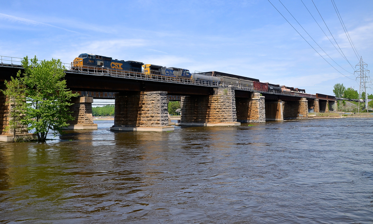 A pair of Dash8-40CW's, in two paint schemes. Two CSXT Dash8-40CW's (CSXT 7808 & CSXT 7884) in two different paint schemes lead a short CN 327 (292 axles) off the island of Montreal on a scorcher of a day.