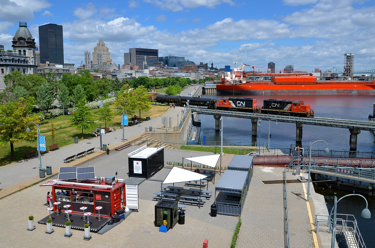 Leaving the port just before lunch time. The Pointe St-Charles switcher is leaving the Port of Montreal with a pair of GP9's (CN 7272 & CN 7204) as it crosses the eastern end of the Lachine Canal just before the area begins to fill up with people flocking to this popular area on their lunch breaks. Behind the power is the ship Venture.