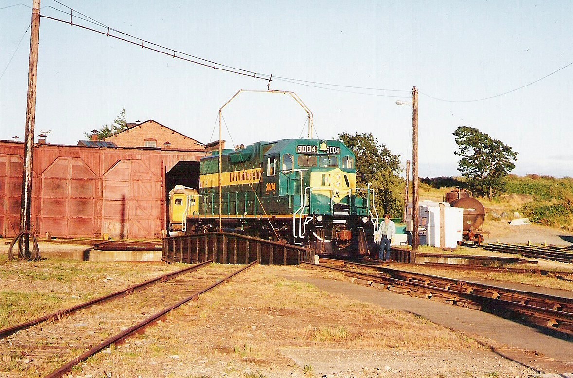 I was lucky enough to be at the Victoria CP roundhouse when E&N (CP) 3004 arrived from Nanaimo. Many times I had watched the VIA cars cross over the turntable, but this was the first time I actually saw a locomotive being turned around on it. Once the locomotive was turned it picked up a few cars, headed back to Nanaimo. At the date of the picture, the roundhouse was only used to maintain the VIA equipment. The E&N took care of their equipment out in the open at Nanaimo. Today the yards in Victoria have been sold off, & all is just a memory.