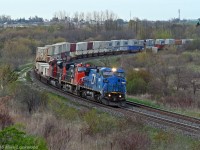 IC 2456, IC 2705, and CN 8851 lead 149's train through the broad curve at Bowmanville. Traces of the one time town spur to the Goodyear plant are slowly succumbing to vegetation or the wrecking crew, the only visible evidence in this view being the path to the left of the train. The shot here is getting tighter and tighter, and unless some foam hero does a little covert trimming, this classic view will be lost. 1914hrs.