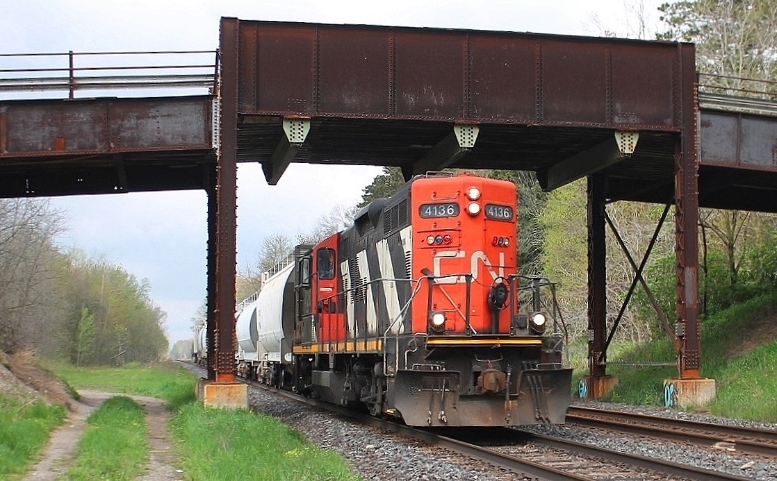 Having worked from Brantford to London 4136 is seen long hood forward as it returns east and passes under Gobles Road bridge. It was see in Princeton heading west on the North track and is returning on the South track. This is the site of mile 40 hot box detector and is to the west of Princeton.