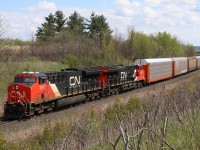 An early production and current production GE T4 are in charge of the days train 382 as it grinds its way east through scotch Block just east of Milton. The main difference in the two versions is the box around the exhaust stack , which is now rounded on the 3058 versus the old square box as seen on 3007. Notable on today's train was a cut of loaded CSX coal cars. 