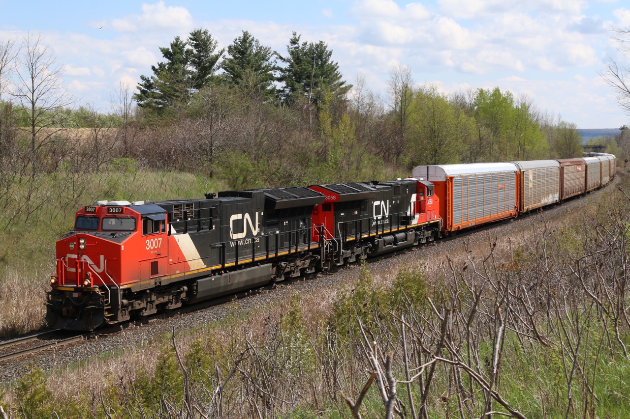 An early production and current production GE T4 are in charge of the days train 382 as it grinds its way east through scotch Block just east of Milton. The main difference in the two versions is the box around the exhaust stack , which is now rounded on the 3058 versus the old square box as seen on 3007. Notable on today's train was a cut of loaded CSX coal cars.