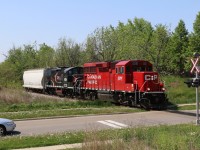 Newly arrived Cando Contracting GP9RM 4014 is along for the ride as it accompanies borrowed CP GP20C 2261 as they head north for Orangeville with one covered hopper in tow. The 4014 will replace out of service 4009 stored at Orangeville. 