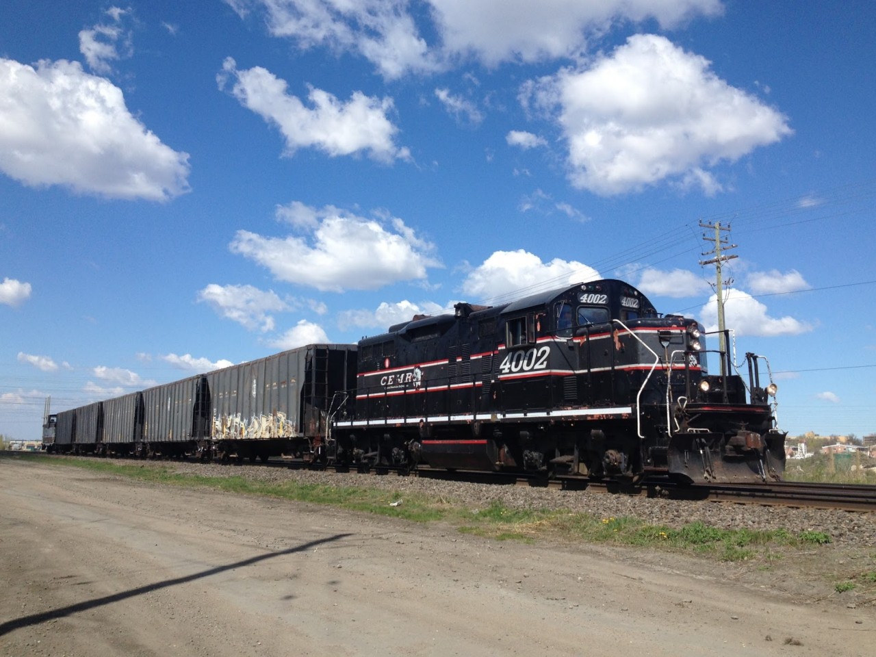 This morning, me and a friend went railfanning on the CN Rivers Subdivision. We saw CEMR 4002 heading east with 5 Ex-IC Ballast Hoppers. To our amazement, they had their caboose (CCGX 200001) on the end! Score!