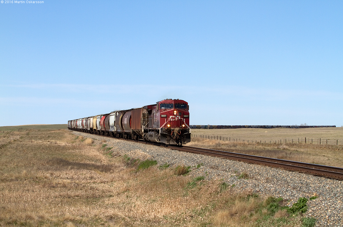 This 124 car eastbound train is seen a few kilometers outside Bowell and has two C44AC as power, 9807 pulling and 9803 pushing.
