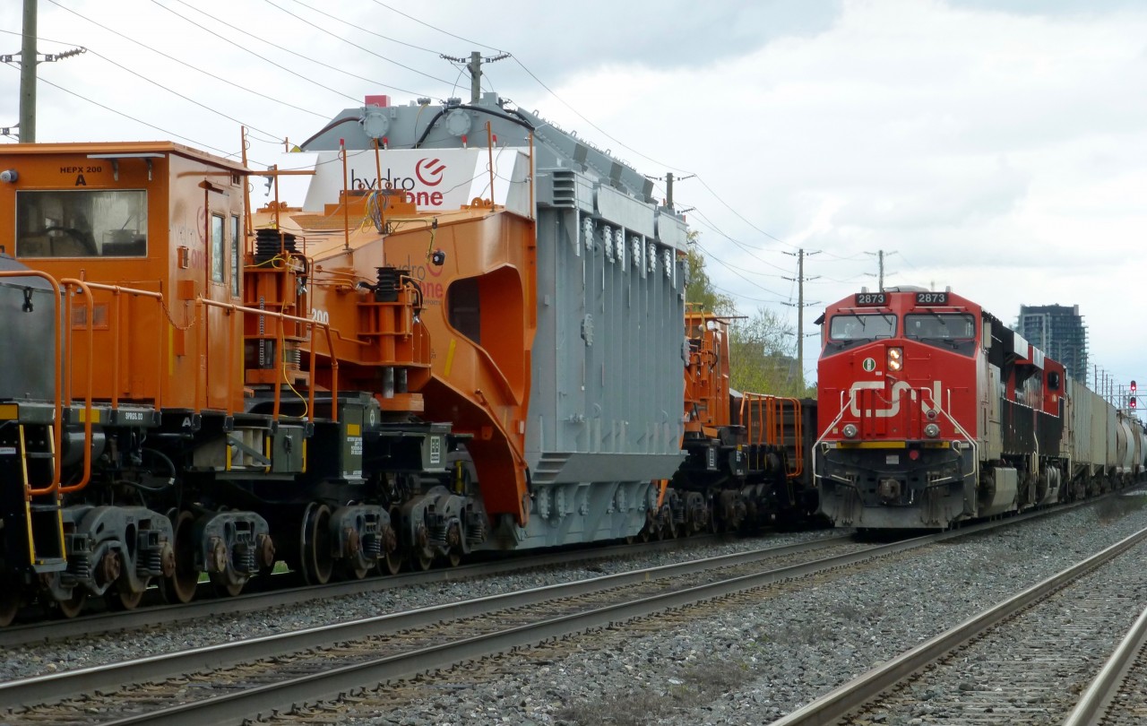 And I thought my locomotives were huge. CN train 435 passes train L350 at Brampton,Ont. L350 was a special move for Hydro One. Because if L350's D9 status, the train must come to a stop if it to be passed by any other non dimensional train. The opposing train must move at 10 mph until clear of L350. The train started out in Hamilton,Ont and was forwarded to the CP Rail interchange at Oshawa, Ont. Tomorrow the CP will pick it up and move it to a location near Oshawa, where it will be offloaded to a low-boy trailer for movement to a Hydro One facility near by. The Schnabel car was built in 1974 by National Steel Car in Hamilton and was rebuilt in 2014