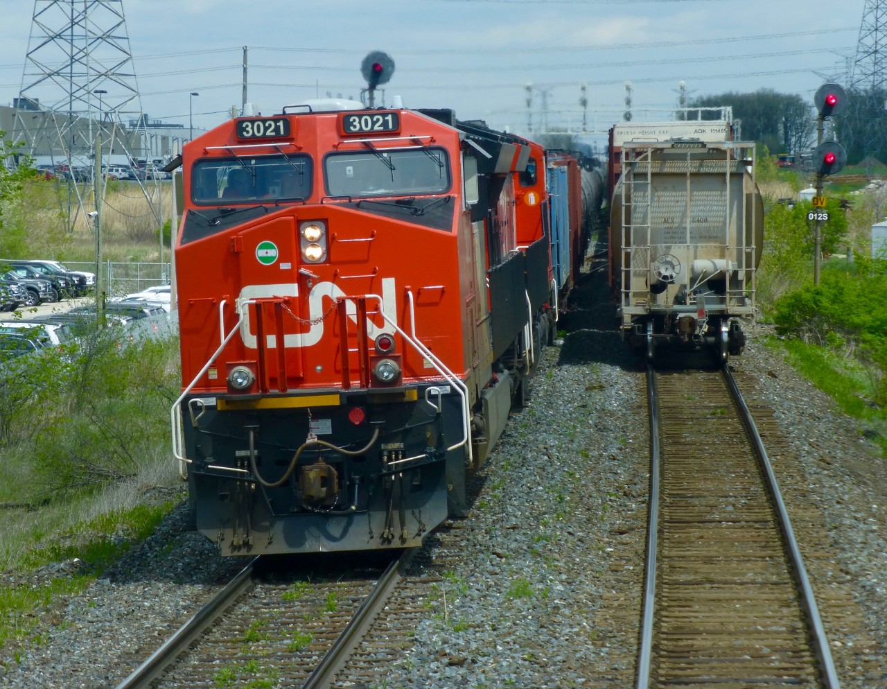 CN train 435 departs Mac Yrd at Snider West lead by CN ET44AC 3021 as the last car of an 11,000ft 422 is clearing the inbound track of the Halton Sub.