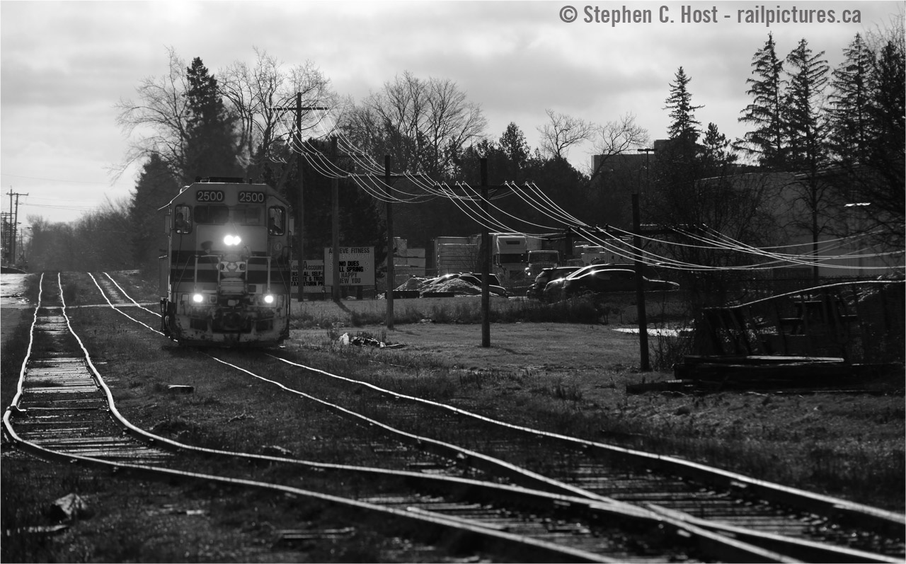 A lone engine heads North on the former CNR Fergus subdivision, once a mainline like any other but now a rickety shadow of itself. Evidence of its mainline past gleams in the morning winter sun - the siding once used to meet trains, and the codeline used to dispatch and communicate to agents and dispatchers to the North and South.