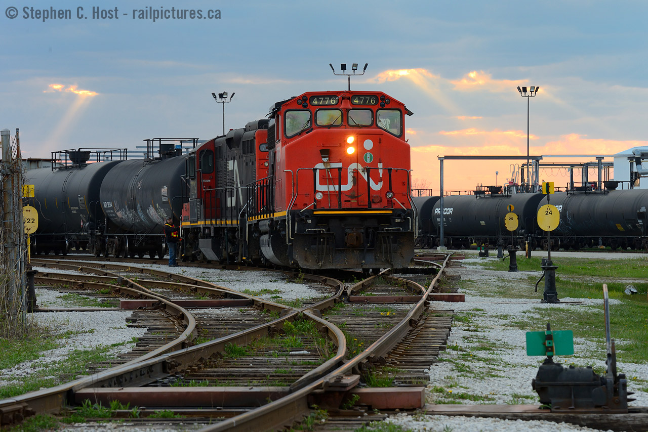 With orange beams of late evening light peeking through holes in the cloud, a CN yard job from Sarnia is switching three cars in (and zero out) of Procor's Sarnia facility.