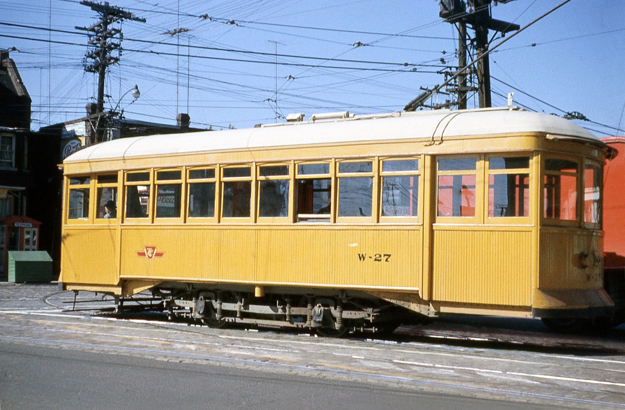 Toronto Transit Commission rail grinder W-27 is pictured at the intersection of College and Lansdowne in October of 1960. This Preston Car and Coach Company 1915-built single truck two axle car was formerly Toronto Civic Railways streetcar 53, before being converted into a snow scraper car and then rail grinder W-27 to serve on the streetcar network. It was later transferred to subway service and became rail grinder RT-7, and was eventually donated to the HCRY (where it joined two other TCR cars that had also become work cars).