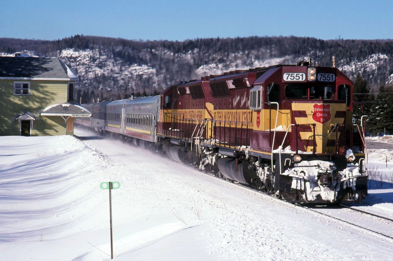 The Snow train passes Searchmont station in a cloud of snow dust in February 1999 with 7551 and 6596 leading. By 1999 Freight units often handled the winter Snow train as the F's were often away in Gladstone-Sault Ste. Marie freight service and the power laying over during the day from the freights north of Steelton was readily available to run up to Canyon and return, then be serviced and still leave on northbound freight 11 near midnight.