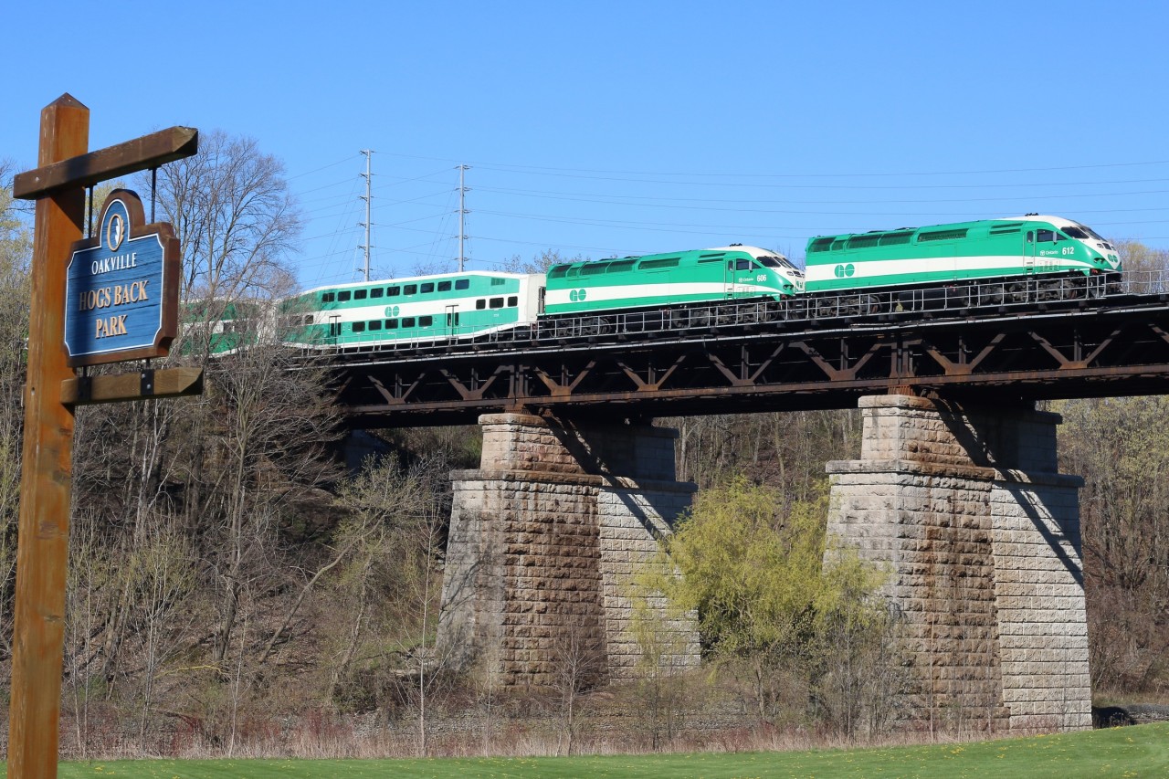 A double headed Eastbound GO train slows for Oakville station as it crosses high above Hogs Back park. The 16 Mile Creek runs between the two piers while Cross Ave is situated out of view to the right.